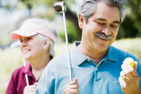 Middle-aged couple with golf clubs Fotos de archivo
