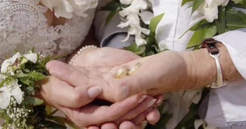 Middle aged couple hold wedding rings in the palm of their hands. Stock Footage 134592999