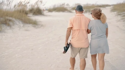 Middle-Aged Couple Holding Hands, Walking on Clearwater Beach Stock Footage 86478058