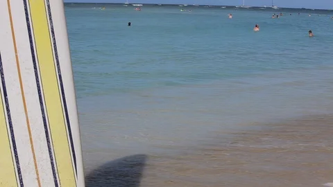 Middle-aged couple holding hands on a beach by a surfboard. Stock-Footage 88367875