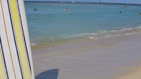 Middle-aged couple holding hands on a beach by a surfboard. 스톡 동영상 88367887