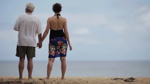 Middle-aged couple holding hands on a beach. Stock Footage 88370047