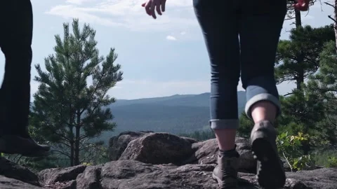 A middle-aged couple, holding hands, climbs the mountains. A sunny summer day. Video stock 170204288