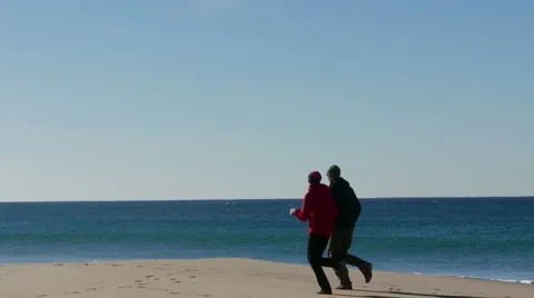 Middle-aged Couple Jogging on Beach Stock Footage 45577100