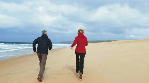 Middle-aged Couple Jogging on Ocean Sandy Beach Stock Footage 68175555