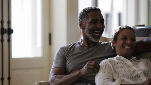 Middle-aged couple laughing on a sofa. Stock Footage 88367418