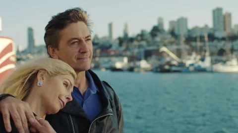 Middle-aged couple look out over the San Francisco Bay sunset Stock Footage 59750042