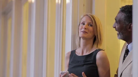 Middle-aged couple looking at a smart phone in a doorway. 스톡 동영상 88369936