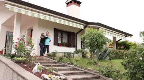 Middle aged couple posing in front of their villa Video stock 47146145