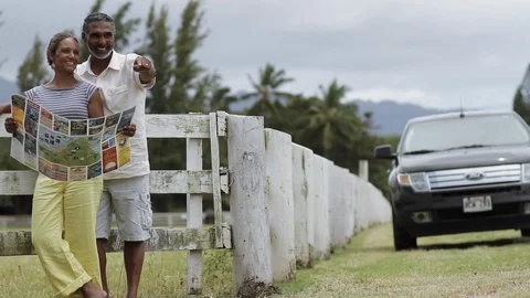 Middle-aged couple reading a map by a fence. Stock Footage 88370277