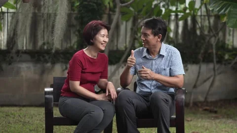 Middle aged couple relax sitting on bench in backyard. Stock Footage 132937496