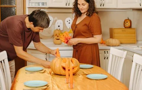 Middle-aged couple sets the table for Halloween party Foto stock