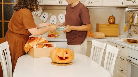 A middle-aged couple sets the table in honor of a Halloween party Stock Photos