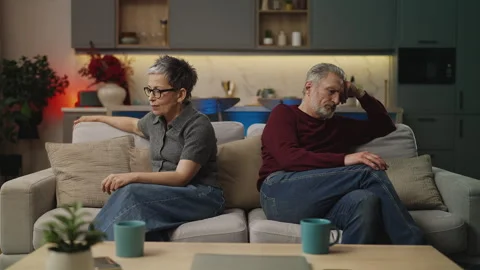 Middle-aged couple sitting apart on sofa, facing relationship problems, crisis Stock Footage 340919893