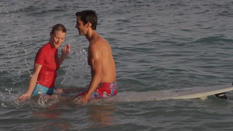 Middle-aged couple sitting on a surfboard. 스톡 동영상 88371610
