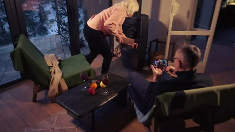 A middle-aged couple spends the evening in front of the fireplace. Stock Footage 265175938