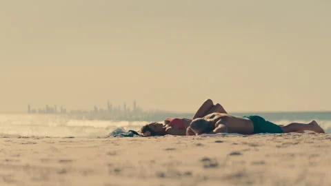 Middle-aged couple sunbathing at the beach Stock Footage 262389132