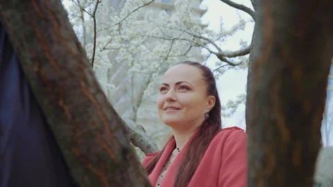Middle-aged couple talking in the park,white flowering under the tree,they held Stock Footage 129502661