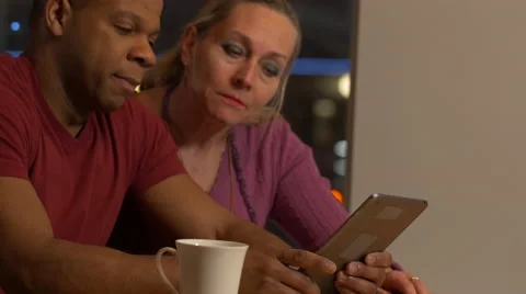 Middle aged couple throws away their newspaper and picks up a tablet Stock Footage 59719271