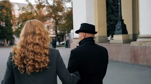 Middle-aged couple walk down the street Stock Footage 68904082