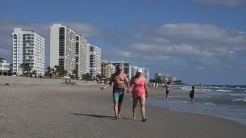 Middle-Aged Couple Walking on Deerfield Beach Stock Footage 200839927