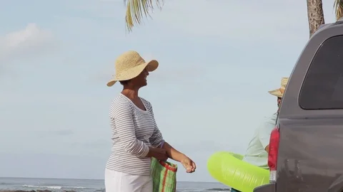 Middle-aged couple walking with inner tubes. 스톡 동영상 88370838