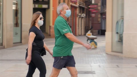 Middle aged couple walking in the streets with face masks Video stock 129616392