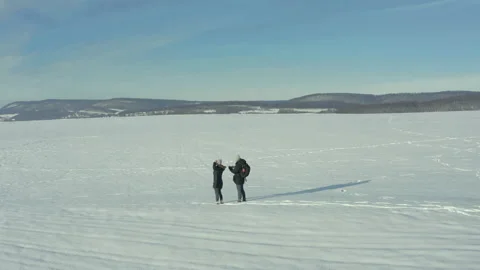 Middle-aged couple in winter clothes hiking through a winter scenery Stock Footage 149212615
