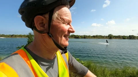 Middle-Aged Cyclist Riding Along Lake Stock Footage 204050771