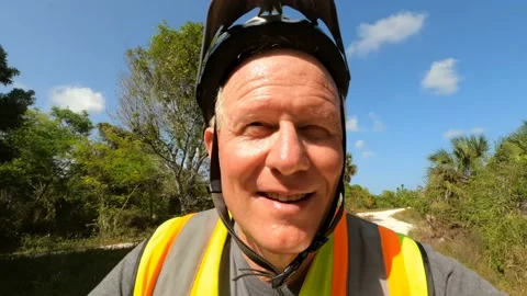 Middle-Aged Cyclist Riding through Shadows of Trees Stock Footage 204050818