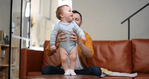 Middle aged dad carrying and playing with newborn baby Stock Footage 154648859