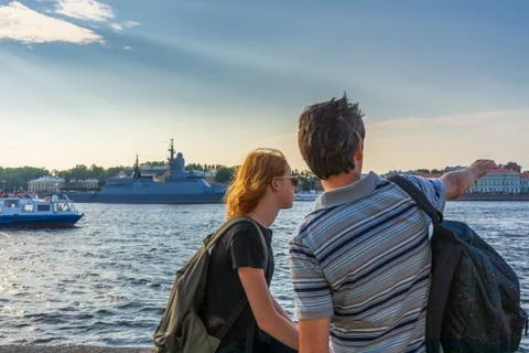 Middle-aged dark-haired man and young redhead lady on Neva river embankment l Foto stock