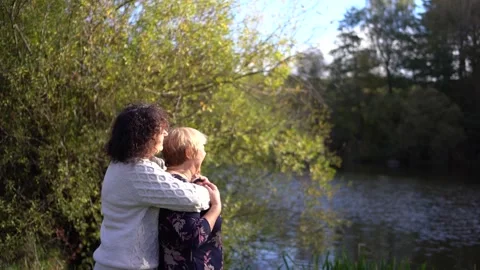 A   middle-aged daughter and elderly mother together on a walk in the autum.. Video stock 289283985
