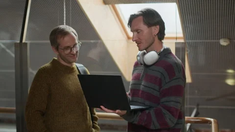 Middle-Aged Developers Discussing Software on Laptop in Office Stock Footage 319994142
