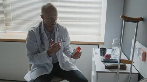 Middle Aged Doctor Explaining Prescription Medication to Male Patient Stock Footage 340634522