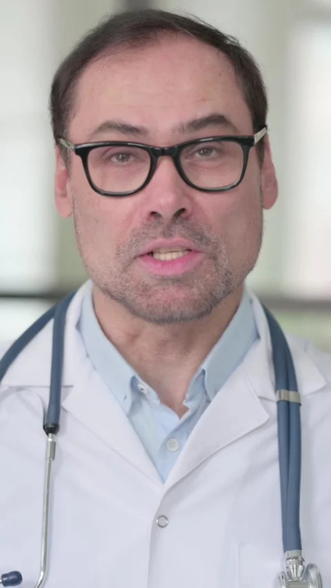 Middle Aged Doctor Talking on Video Call, Vertical Video 動画素材 339583436