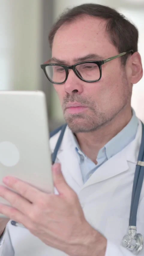 Middle Aged Doctor using Digital Tablet, Vertical Video Stock Footage 339583464