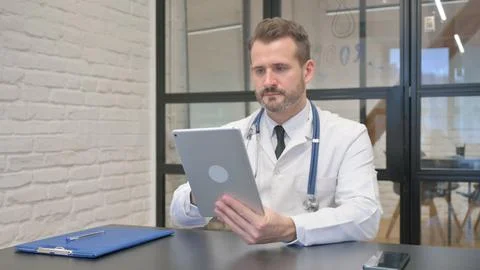Middle Aged Doctor Using Digital Tablet for Work Stock Photos