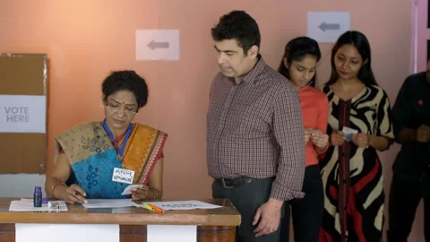 A middle-aged election officer checking the documents of the voters - identit... Video stock 170486416