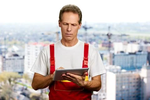 Middle aged engineer using digital tablet. Stock Photos