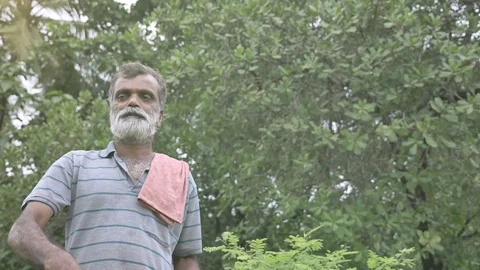 A middle aged farmer walking and dispersing or throwing grains in the farm. Stock Footage 115485661