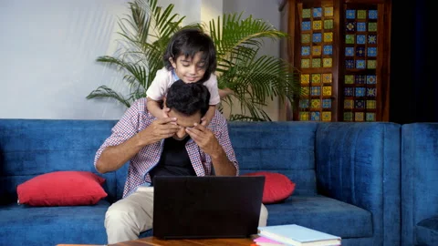 A middle-aged father working remotely on his laptop, Young son - parenting, s... Video stock 165646214