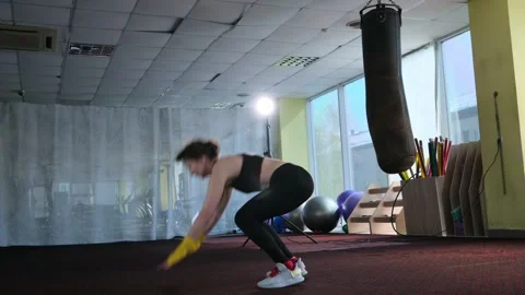 Middle aged female athlete doing burpee exercise in gym. Stock Footage 306598620