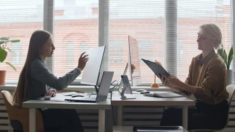 Middle-Aged Female IT Manager Checking Work of Her Junior Colleague in Office Stock Footage 321051704