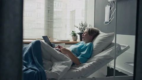Middle Aged Female Patient Using Laptop in Hospital Bed Stock Footage 347874735