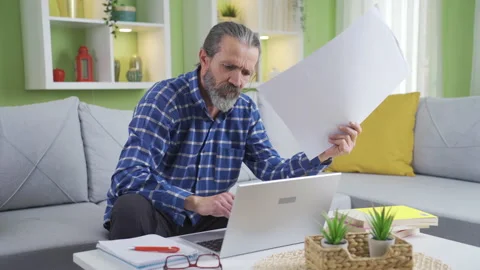 Middle aged freelancer man working in living room at home using laptop. Video stock 230984262