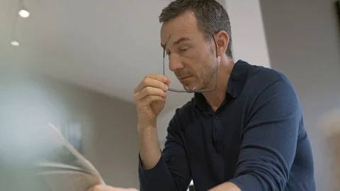 Middle-aged guy at home reading newspaper Stock Footage 124525047