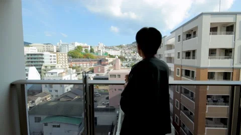 Middle aged guy looks outside from balcony. Silhouette. Dolly in. Stock Footage 224903456