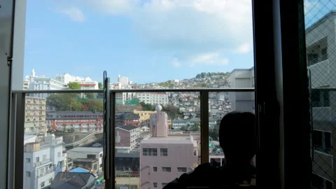 Middle aged guy sit and relax on balcony. Silhouette. Dolly to left. 25P. Stock Footage 224898672