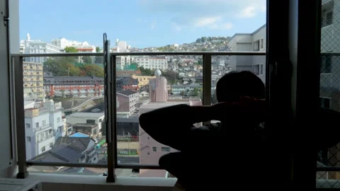 Middle aged guy sit and relax on balcony. Silhouette. 25P. Stock Footage 224898801